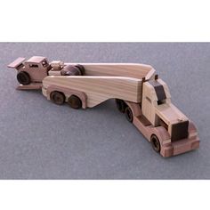 a wooden model of a semi - truck on a gray surface with the trailer attached to it