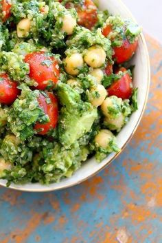 a salad with tomatoes and avocado in a bowl