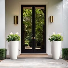 two large white planters sitting in front of a door