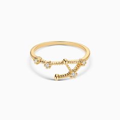 a yellow gold ring with diamonds on the bottom and an arrow in the middle,