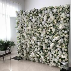 there is a large artificial flower wall in the living room with white flowers on it