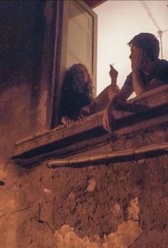 two people sitting on a window sill