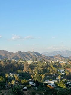 the mountains are covered with trees and houses in the foreground, as seen from an overlook point