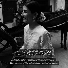 a woman standing next to a horse drawn carriage on a street with an arabic quote