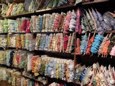 many different colored lollipops are on display in a store with wooden shelves