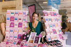 a woman standing in front of a table with lots of cards and magnets on it