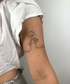 a woman's arm with a tattoo that has a line drawing on the side