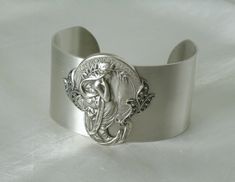 "This beautiful bracelet has a silver plated cuff with silver plated art nouveau maiden and silver plated leaf accents. 1.5\" wide." Victorian Hallmarked Silver Cuff Bracelet, Victorian Silver Hallmarked Cuff Bracelet, Art Nouveau Bracelet Jewelry Gift, Art Deco Bangle Jewelry As A Gift, Adjustable Silver Art Deco Bracelets, Art Deco Bangle Jewelry For Gifts, Victorian Style Silver Bracelets As Gift, Art Deco Bangle Jewelry Gift, Antique Silver Nickel-free Cuff Bracelet