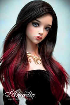 a doll with long red hair wearing a black dress and gold necklace on it's neck