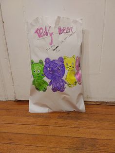 a bag with teddy bears painted on it sitting on the floor in front of a door