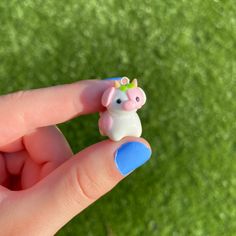 a small toy pig sitting on top of a finger