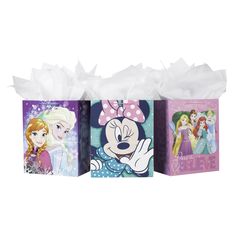 three disney princess gift bags with white tissue paper on the front and one has a minnie mouse