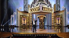 a man standing on top of a stage in front of an audience at a theater