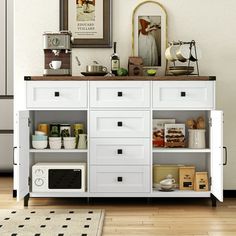 a kitchen with white cabinets and drawers in it's center area, next to a microwave