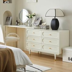 a bedroom with white furniture and pictures on the wall