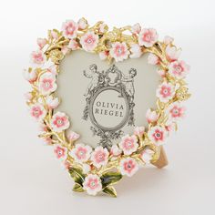 a heart shaped frame with pink flowers and leaves on the edges is shown in front of a white background