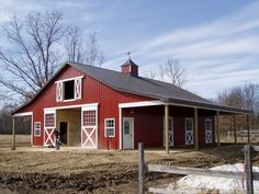 a red barn with a white door and windows