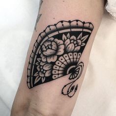 a woman's arm with a black and white tattoo design on the left forearm