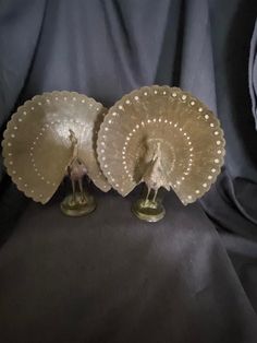 two decorative figurines are sitting next to each other on a black cloth background