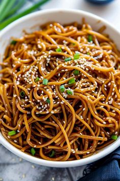 a white bowl filled with sesame seed noodles