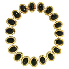 This striking Mid-20th Century 18K yellow gold choker length necklace is comprised of nineteen oval shaped links. Each link is set with one large onyx cabochon surrounded by a high polish finish 18K gold bezel. A cleverly hidden hook clasp secures it at the rear. Each link measures 1 inch by 3/4 inch. Overall length is 16 1 /2 inches. It bears no markings but does test solidly as 18K gold. Gross weight 110.75 grams. Luxury Black Jewelry With Gold Beads, Length Necklace, Gold Choker, Wedding Jewellery Necklace, Hook Clasp, Link Necklace, Wedding Necklace, Black Onyx, 20th Century