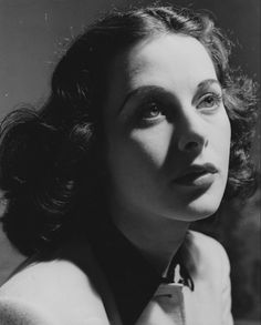 an old black and white photo of a woman with her eyes half closed, wearing a collared shirt