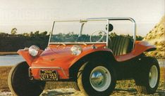 an old red jeep parked on the side of a road next to a body of water