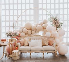 a living room filled with furniture and balloons on the wall behind it is a couch