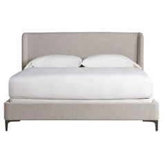 a bed with white sheets and pillows on it