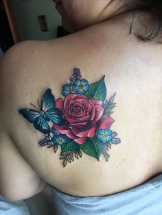 a woman with a rose and butterflies tattoo on her back shoulder, which is covered in blue flowers