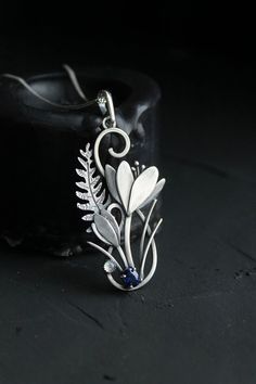 ITEM DESCRIPTION:The size  H 5 cm x W 3 cm (2 x 1 inch). Weight - 4 g. You can buy it with a silver chain or without it.I made this unique Crocus pendant of sterling silver, dark blue sapphire and moonstone. This is similar to the first spring flowers that appear from under the snow. The floral necklace looks so gentle and elegant! This handmade necklace will come to you in a gift box - ready for gifting.**********The parcel will be sent during 1-2 days after payment. Delivery usually takes 10-2 Elegant Flower-shaped Large Pendant Jewelry, Elegant Flower Shaped Large Pendant Jewelry, Elegant Floral Large Pendant Jewelry, Handmade Botanical Flower Pendant Jewelry, Unique Flower-shaped Metal Jewelry, Unique Flower Shaped Metal Jewelry, Unique Metal Flower Jewelry, Metal Pendant Jewelry With Flower Charm, Nature-inspired Silver Flower Necklace With Charm