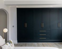 a bedroom with black cabinets and white bedding