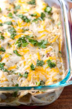 a casserole dish with cheese and spinach in it on a wooden table