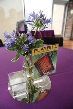 there is a vase with flowers in it and a book on the table next to it