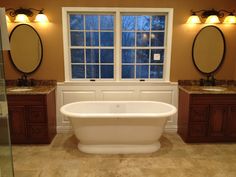 a large bathroom with two sinks and a bathtub in the middle of the room