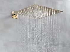 an overhead shower head with rain coming down from it's side and the water running