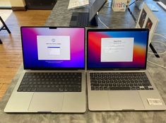 two laptops sitting side by side on a table