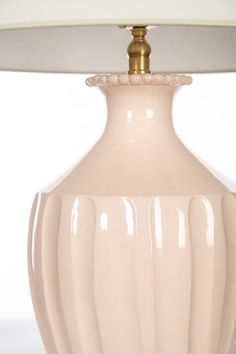 a lamp with a white shade on top of it and a light in the middle