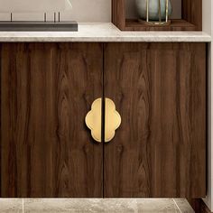 the cabinet doors are made of wood and have brass pulls on them, along with a marble countertop