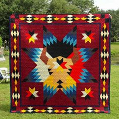 a red quilt with stars on it in the grass