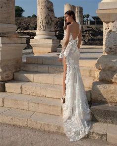 a woman in a white dress standing on some steps