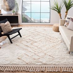 a living room filled with furniture and a white rug on top of a hard wood floor