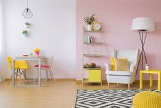 a living room with pink walls and yellow chairs in the corner, white table and black and white rug