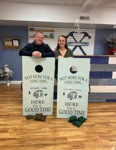 two people standing next to each other holding up cornhole tossers that say, not here for a long time