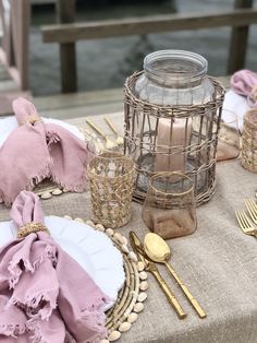 a table topped with plates and napkins next to a cage filled with goldware