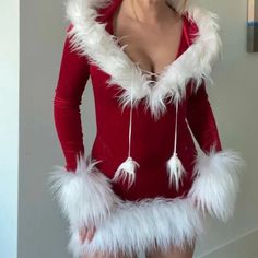 a woman in a santa costume posing for the camera with her hands on her hips