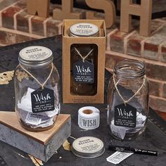 two glass jars with labels on them are sitting on a table next to some other items