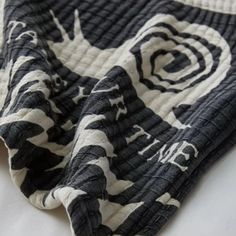 the black and white blanket is laying on top of the bedding with an abstract design