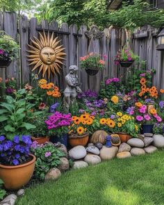 a garden filled with lots of flowers next to a wooden fence and a stone wall