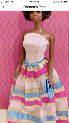 a barbie doll wearing a pink and blue dress with gold stripes on it's skirt